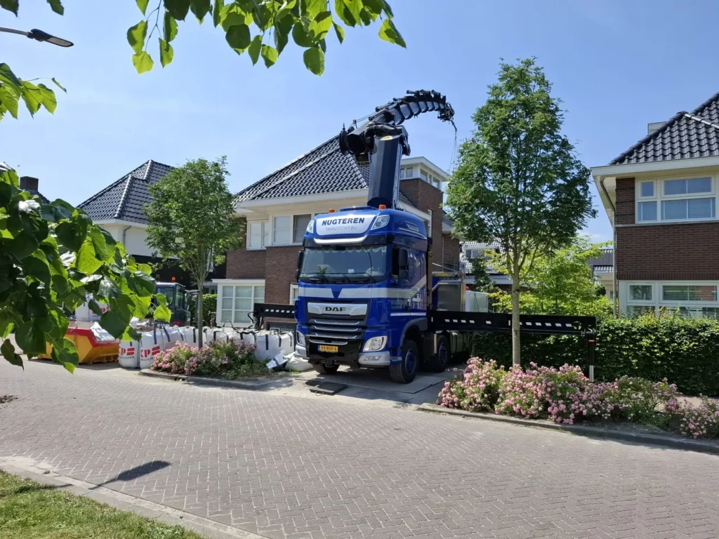 Kraanwagen van Nugteren Transport aan het werk in een woonwijk