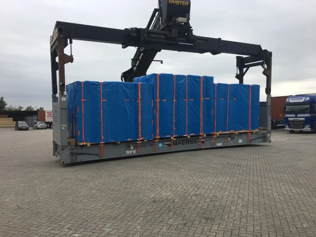 Verpakte lading met oranje sjorbanden vastgezet op een flatrack