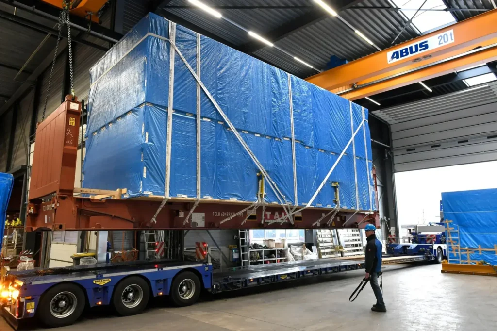 Verpakte lading op een mafi onder de bovenloopkraan in de loods